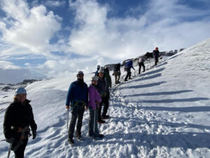 adventures for all group hiking up a snow covered landscape